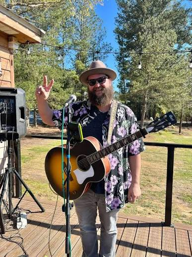 Brandon Butler with his acoustic guitar at an outdoor show